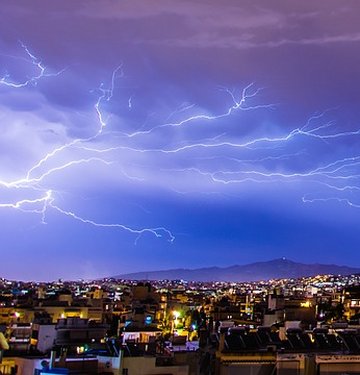 A picture of lightning bursting over a city.