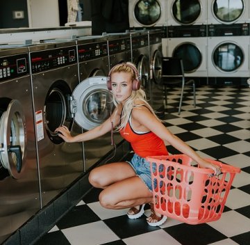 A picture of a woman in a laundromat.