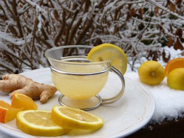 A picture of tea with lemon and ginger on the side.